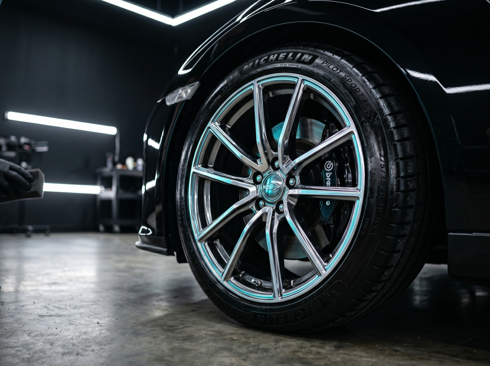 Glossy dressed tire and polished wheel with an ice-cyan highlight